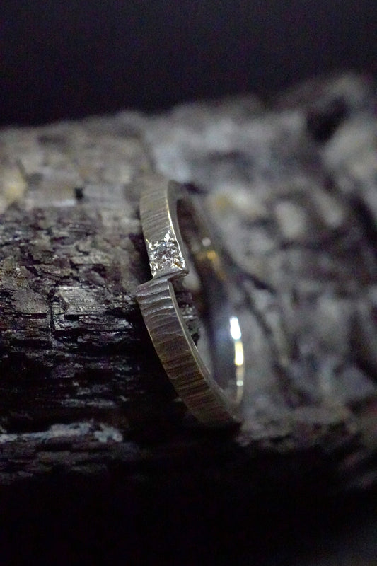 Bague martelée basalte, asymétrique fine sertie d'un diamant (argent 940 recyclé et diamant de culture)